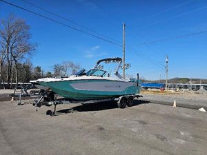 MasterCraft XT24 - CLEARENCE !! 2023 MasterCraft XT24 boat on trailer in outdoor setting.