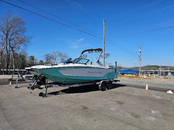 MasterCraft XT24 - CLEARENCE !! 2023 MasterCraft XT24 boat on trailer in outdoor setting.