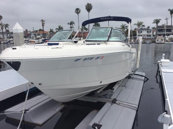 Robalo R227 Dual Console 2021 Robalo R227 Dual Console boat docked in a marina with palm trees.