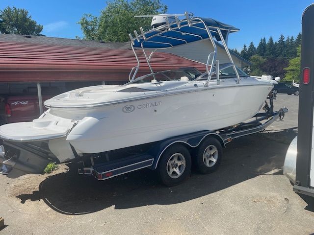 Cobalt 220 2006 Cobalt 220 boat on trailer, white exterior, parked outdoors under clear blue sky.