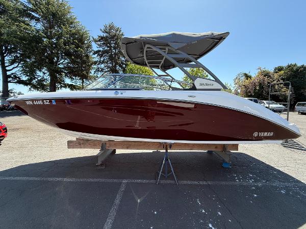 Yamaha Boats 252SD 2022 Yamaha Boats 252SD in red, parked outdoors on a sunny day.