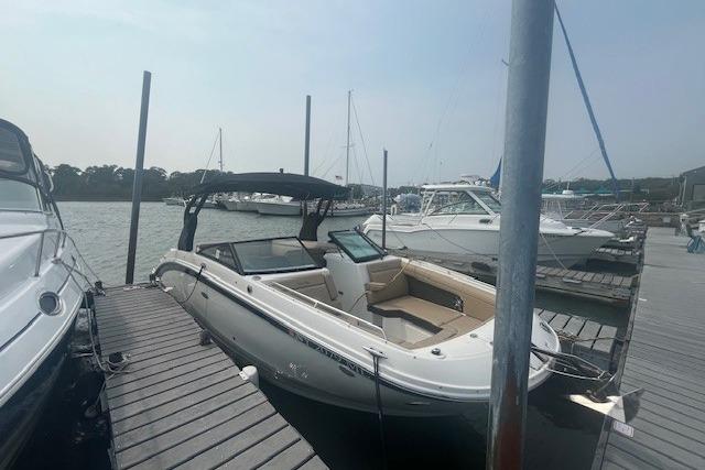 Sea Ray SDX 270 2019 Sea Ray SDX 270 boat docked at a marina under a clear sky.