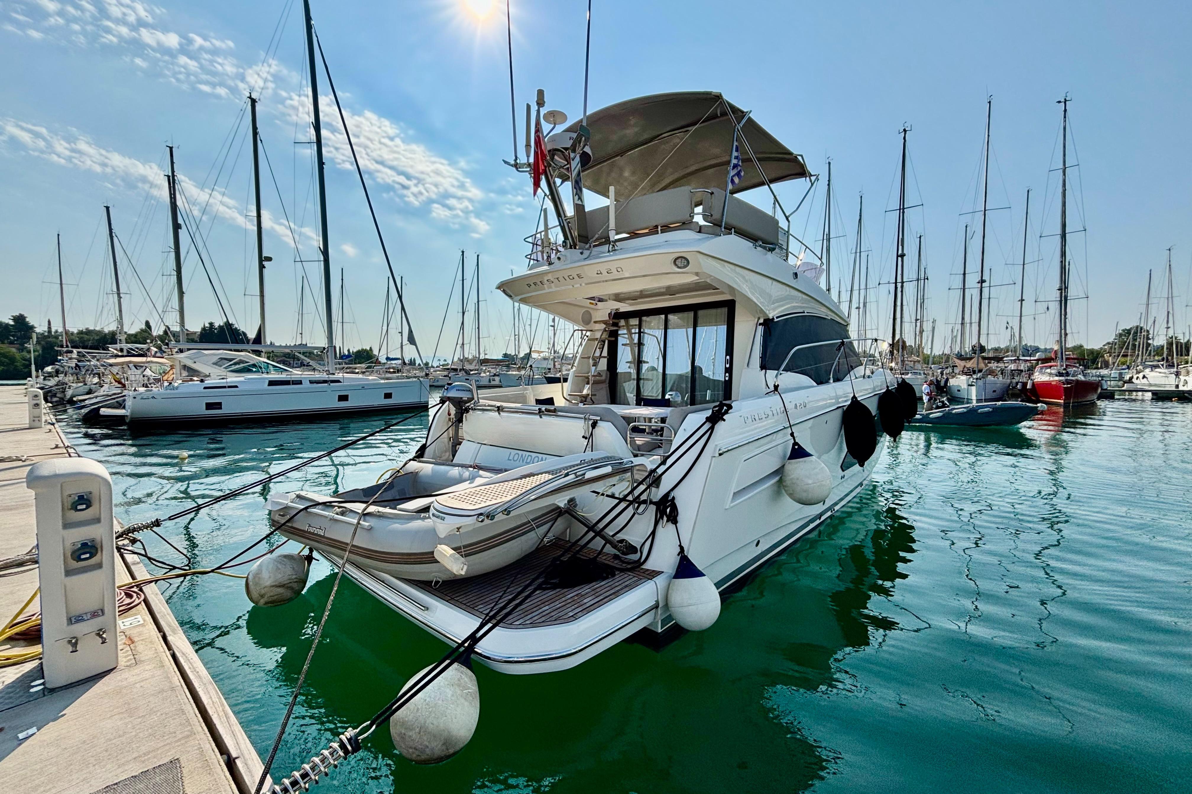Jeanneau Prestige 420 Flybridge 2020 Jeanneau Prestige 420 Flybridge yacht docked in a marina, surrounded by sailboats.