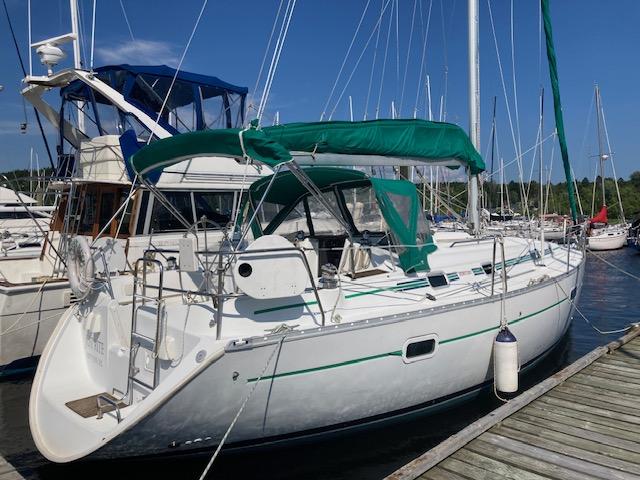 Beneteau 361 Sailboat docked at marina, 2002 Beneteau 361 with green canopy and white hull.