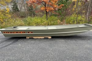 Tracker Grizzly 1436 Utility 2025 Tracker Grizzly 1436 Utility boat on pavement, surrounded by autumn foliage.
