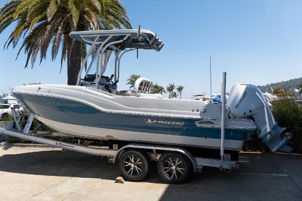 Finseeker 230 CC 2023 Finseeker 230 CC boat on a trailer, parked near palm trees.