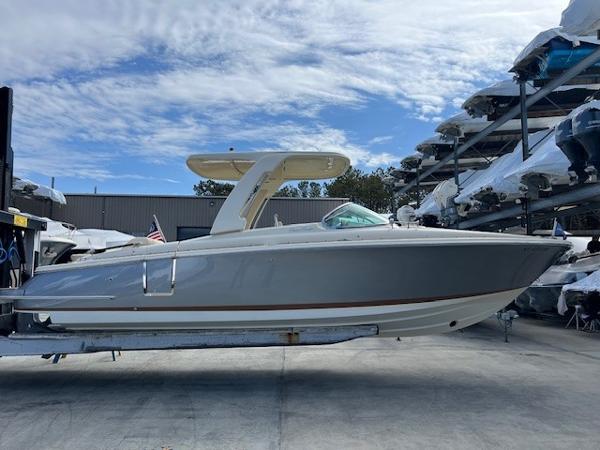Chris-Craft Launch 28 GT 2022 Chris-Craft Launch 28 GT boat in storage, side view under a partly cloudy sky.