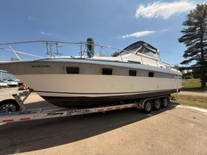 Cruisers 337 1986 Cruisers 337 boat on trailer under clear sky.