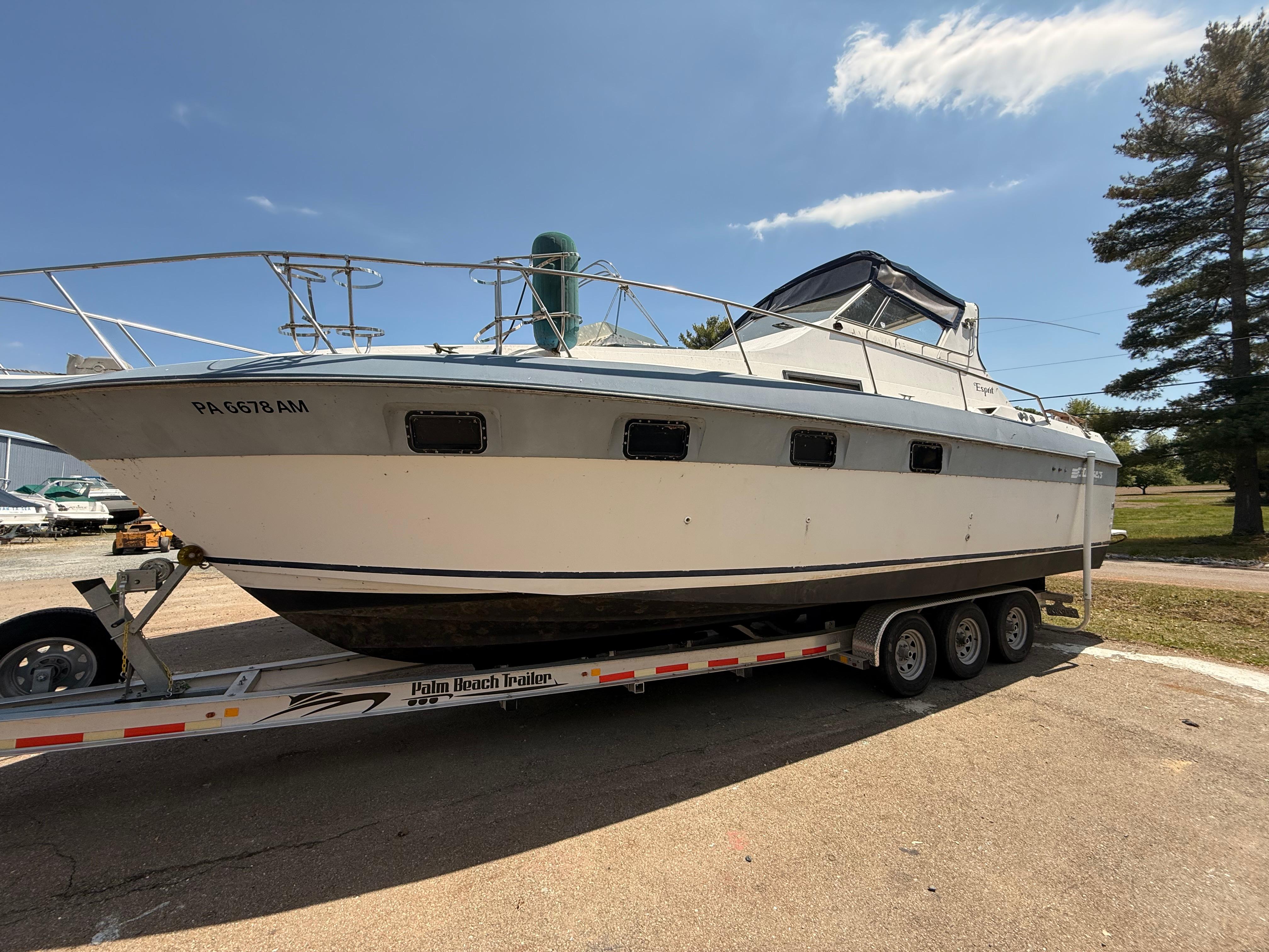 Cruisers 337 1986 Cruisers 337 boat on trailer under clear sky.