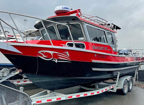 North River 2700 SXL 2016 North River 2700 SXL boat on trailer, red and black design, docked outdoors.