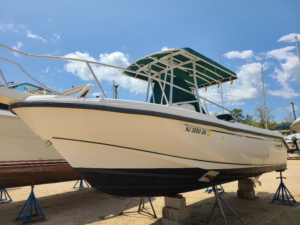 Boston Whaler 23 Outrage 2000 Boston Whaler 23 Outrage boat on stands under a clear blue sky.