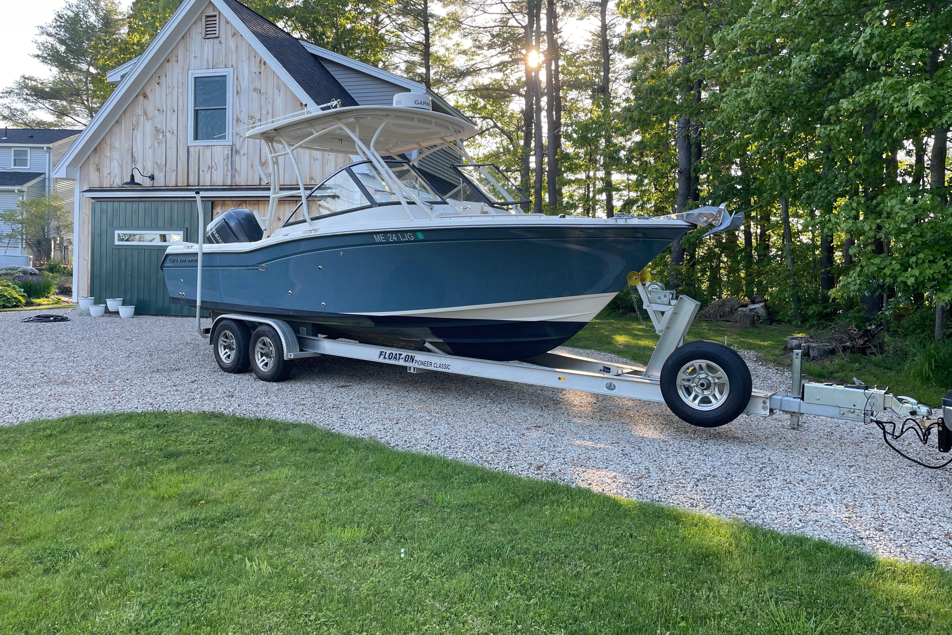 Grady-White Freedom 255 2015 Grady White 255 Freedom boat on trailer, parked near a wooden garage.