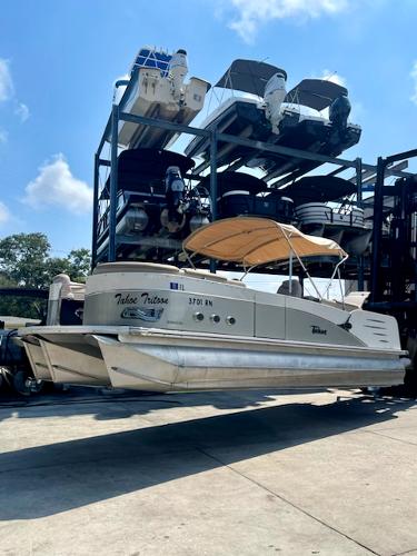 Tahoe 2586 QL 2016 Tahoe 2586 QL pontoon boat in storage, sunny day, blue sky.