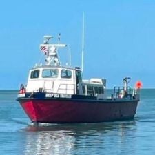 Custom Commercial 1964 custom commercial boat "Deep Sea Transporter" on calm water under clear blue sky.