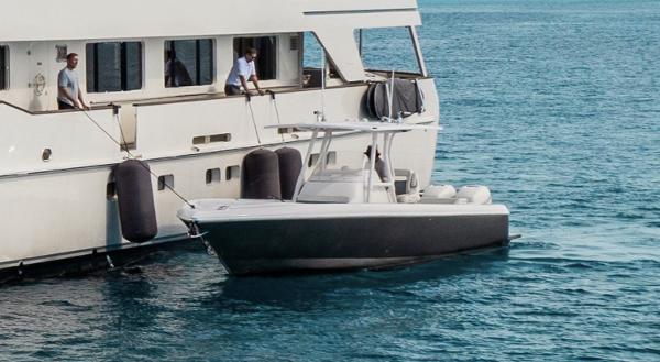 Intrepid 327 Center Console 2016 Intrepid 327 Center Console boat docked beside a larger yacht on calm water.