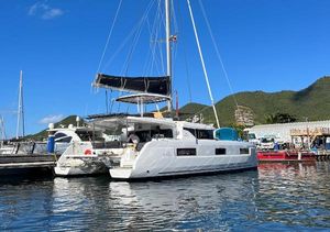 Lagoon 46 2023 Lagoon 46 catamaran docked at a marina with scenic mountain backdrop.
