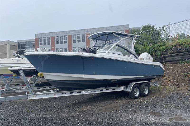 Edgewater 248CX 2024 Edgewater 248CX boat on trailer, parked outdoors near a building.