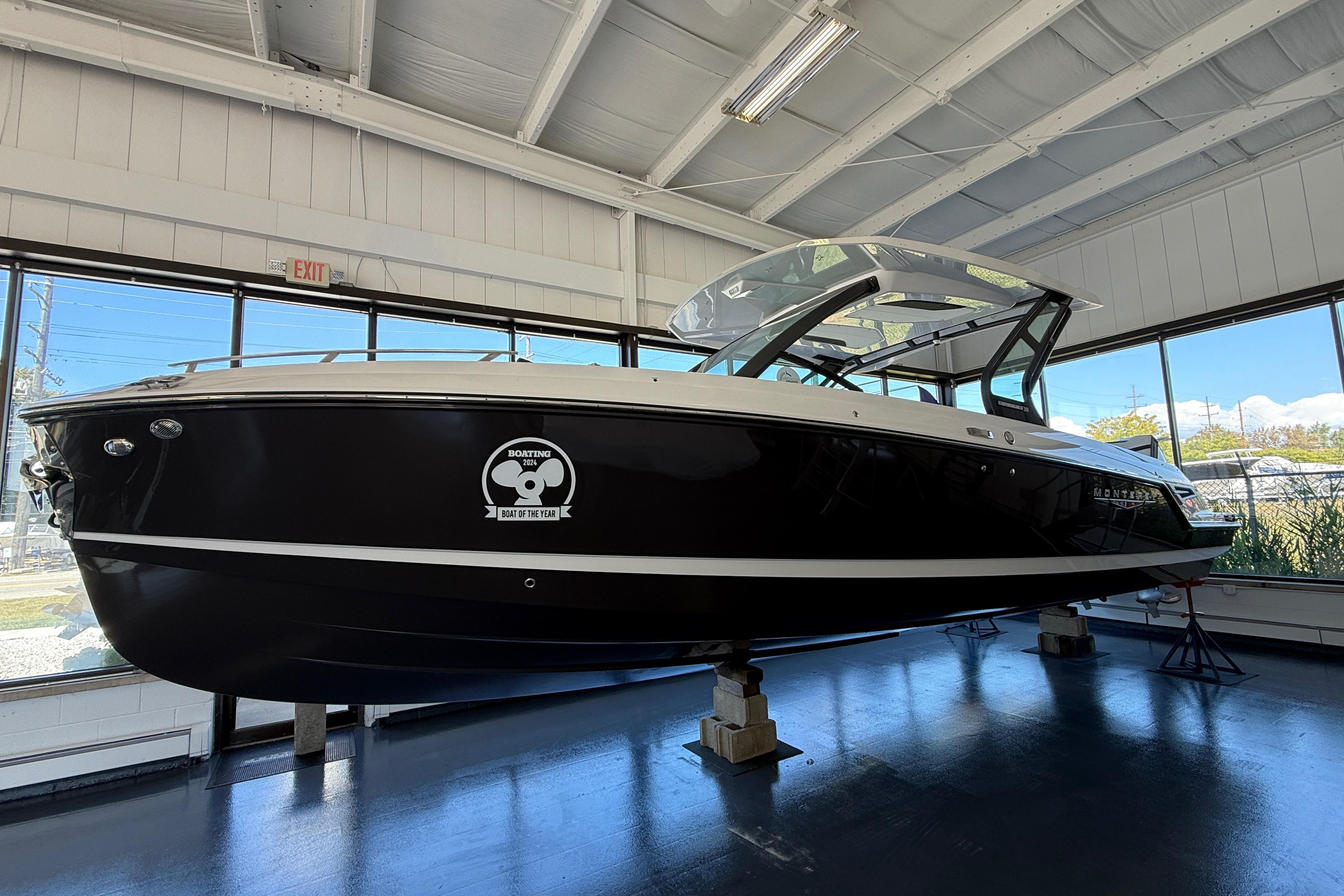 Monterey Elite 30 OB 2026 Monterey Elite 30 OB boat displayed indoors, showcasing sleek black design.