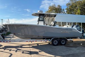 NauticStar 28 XS 2023 NauticStar 28 XS boat on trailer, parked outdoors under clear sky.