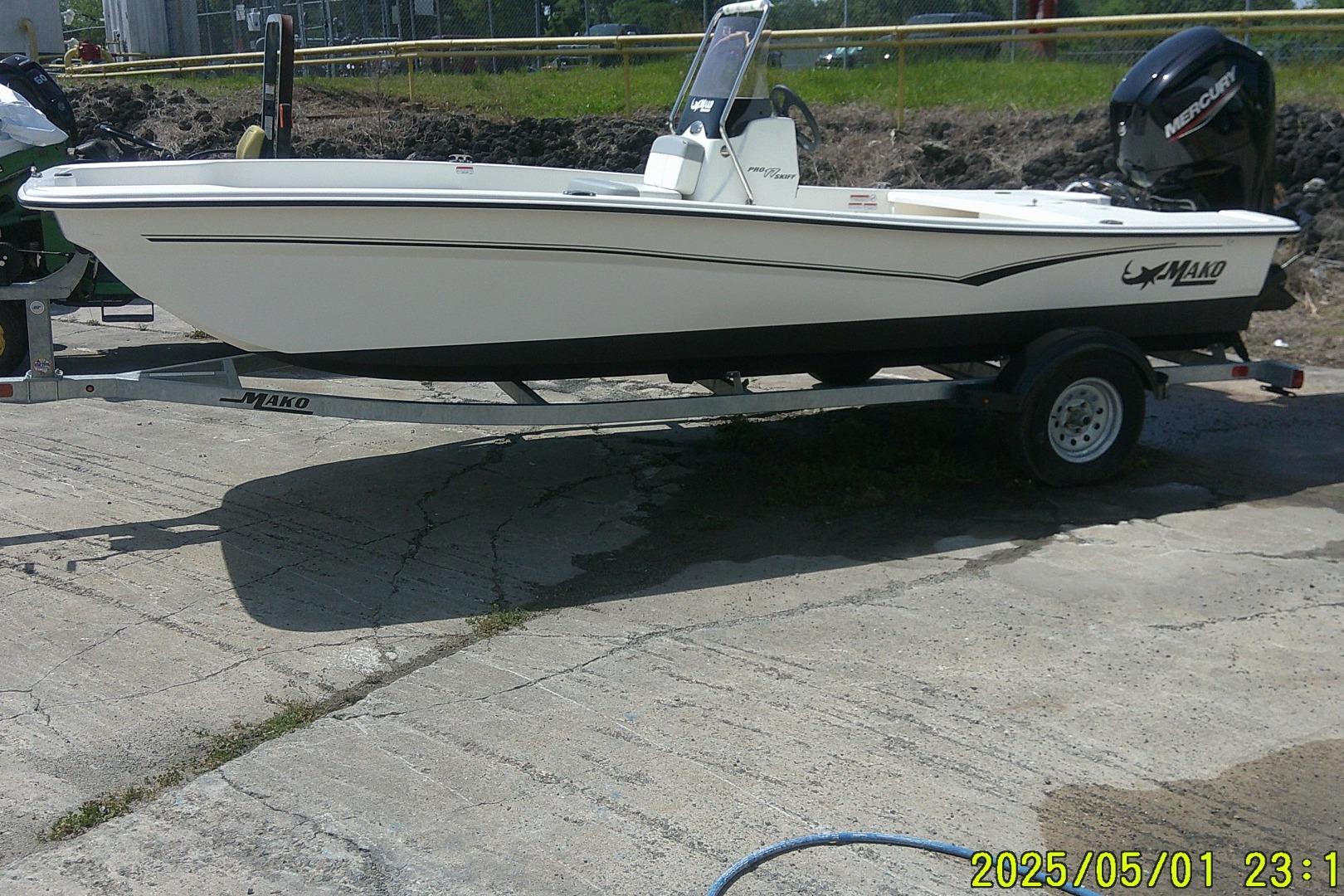 Mako Pro Skiff 17 CC 2024 Mako Pro Skiff 17 CC boat on trailer, parked outdoors.