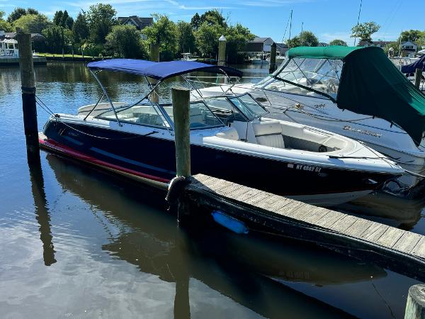Cobalt A28 2015 Cobalt A28 boat docked in a marina with blue canopy.