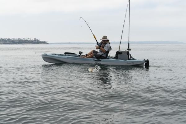 Hobie Mirage Passport 12.0 Man fishing on a 2025 Hobie Mirage Passport 12.0 kayak in calm waters.