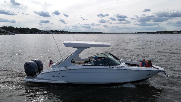 Regal 29 OBX 2024 Regal 29 OBX boat cruising on a lake with passengers.
