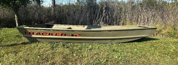 Tracker Grizzly 1236 Utility 2025 Tracker Grizzly 1236 Utility boat on grass, surrounded by trees.