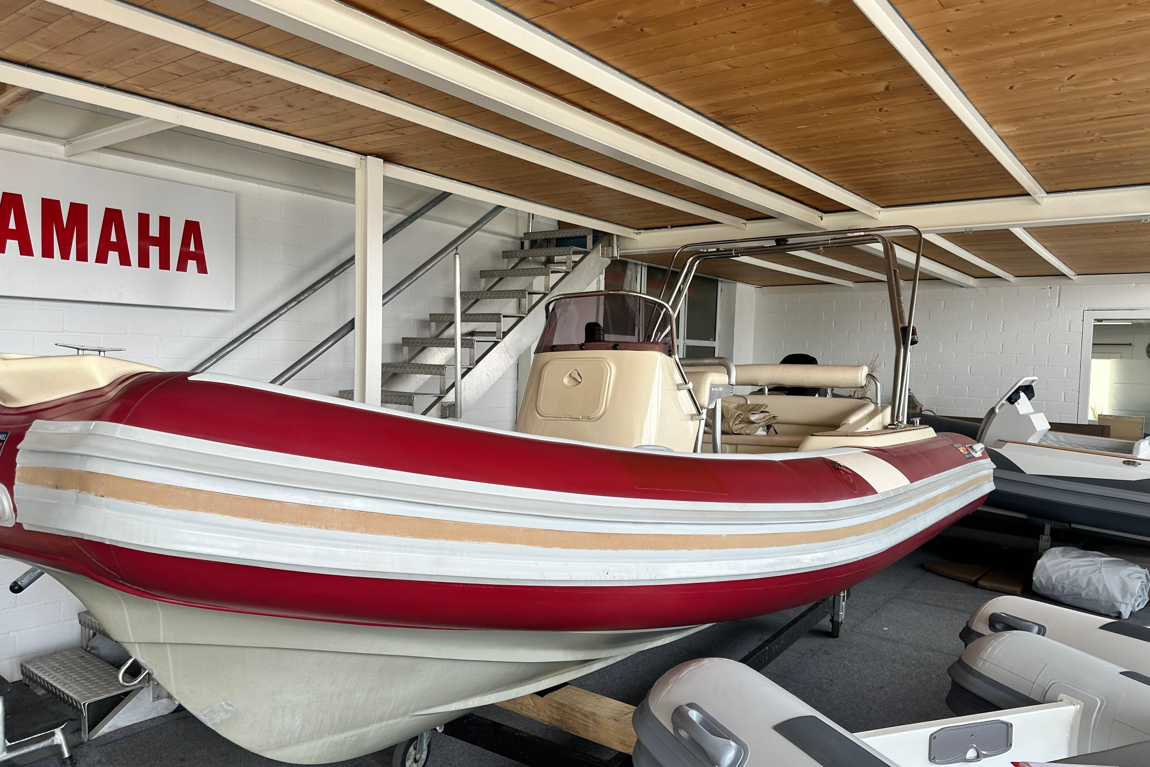 Pischel Ribline 5.5 XL Red and white 2004 Pischel Ribline 5.5 XL boat displayed indoors near Yamaha sign.
