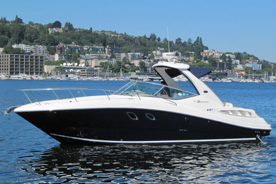 Sea Ray 310 Sundancer 2007 Sea Ray 310 DA Sundancer yacht on calm water with scenic city backdrop.