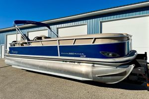 Regency Sun Tracker Party Barge 2012 Regency Sun Tracker Party Barge pontoon boat parked outside a blue building.