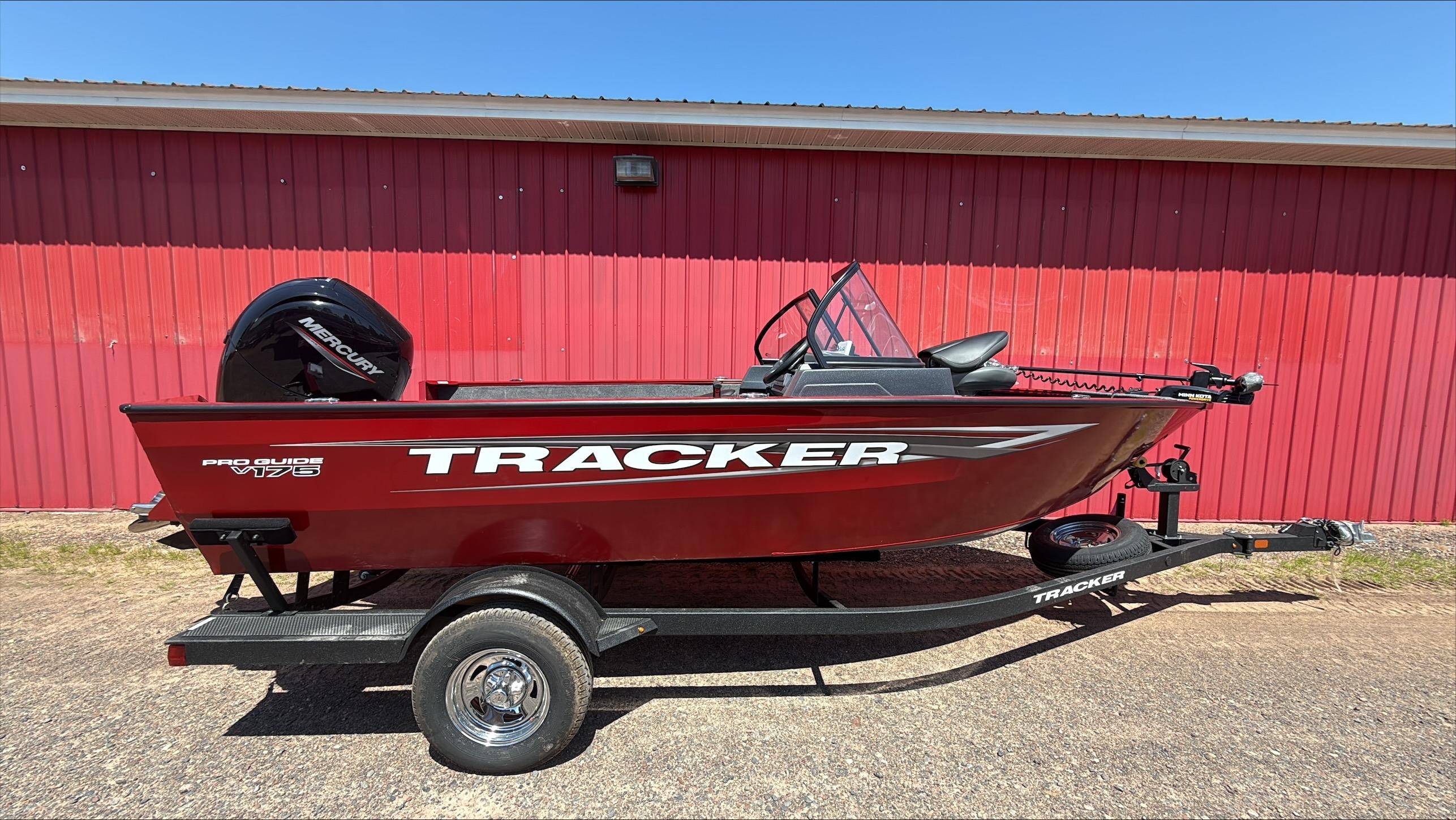 Tracker Pro Guide V-175 Combo 2025 Tracker Pro Guide V-175 Combo boat on trailer, red exterior, parked by red building.