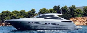 Pershing 56 2007 Pershing 56 yacht cruising near a scenic coastline with lush greenery.