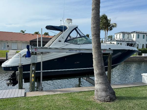 Sea Ray 350 Sundancer 2011 Sea Ray 350 Sundancer yacht docked by waterfront homes, palm trees in background.