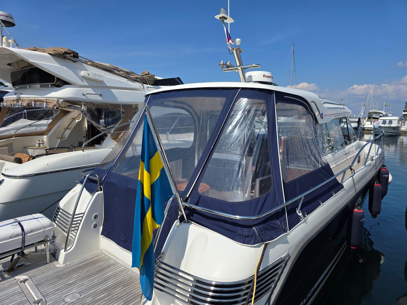 Nimbus 350 Coupe Nimbus 350 Coupe 2006 yacht docked, featuring Swedish flag and clear canopy under blue sky.