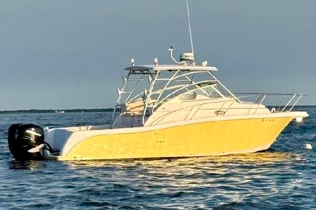 Pro-Line 32 Express 2006 Pro-Line 32 Express boat with yellow hull on open water.