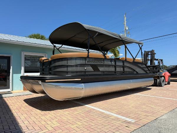 Bennington 24 MSB 2025 Bennington 24 MSB pontoon boat with canopy, parked on brick pavement under clear blue sky.