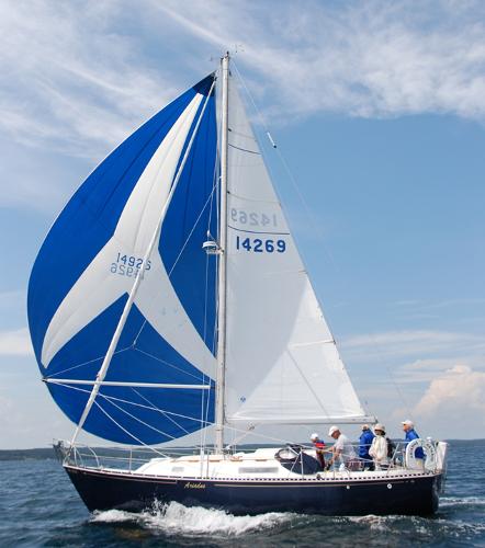 C&C 30 1974 C&C 30 sailboat with blue and white sails on open water.