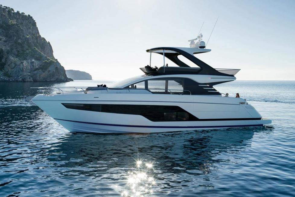 Fairline Squadron 58 2026 Fairline Squadron 58 yacht cruising on serene waters near a rocky coastline.