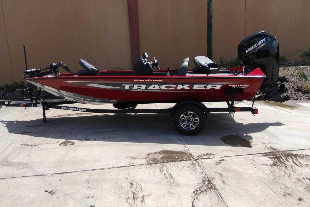 Tracker Pro Team 175 2025 Tracker Pro Team 175 boat on trailer, red with Mercury outboard motor.