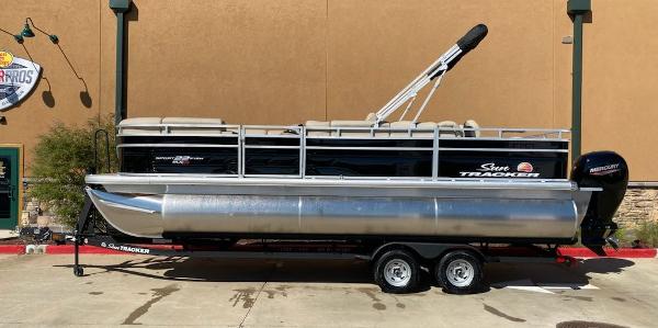 Sun Tracker SportFish 22 XP3 2025 Sun Tracker SportFish 22 XP3 pontoon boat on trailer, parked outdoors.