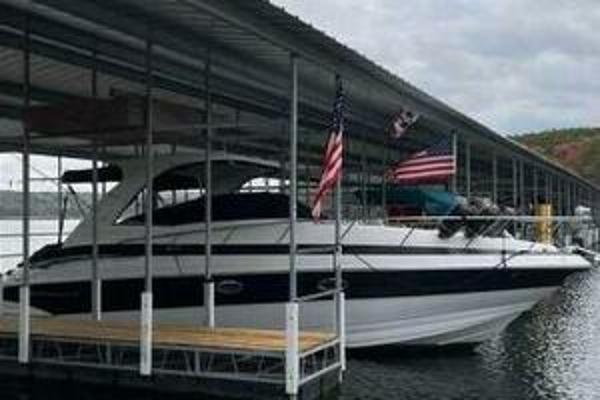 Crownline 340 CR 2006 Crownline 340 CR boat docked under a covered marina with flags displayed.