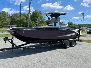Scarab 255 Open ID 2021 Scarab 255 Open ID boat on trailer, parked outdoors under blue sky.
