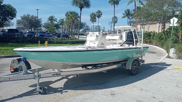 Mako 18 LTS 2022 Mako 18 LTS boat on a trailer in a sunny parking lot.