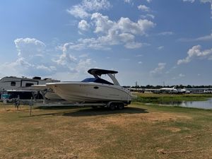 Chaparral 264 Sunesta 2012 Chaparral 264 Sunesta boat on trailer, parked near RVs by a lake.