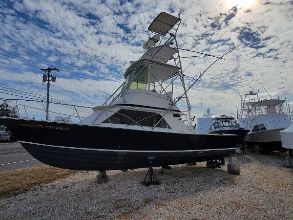 Blackfin 32 Flybridge 1980 Blackfin 32 Flybridge boat on dry dock under a partly cloudy sky.