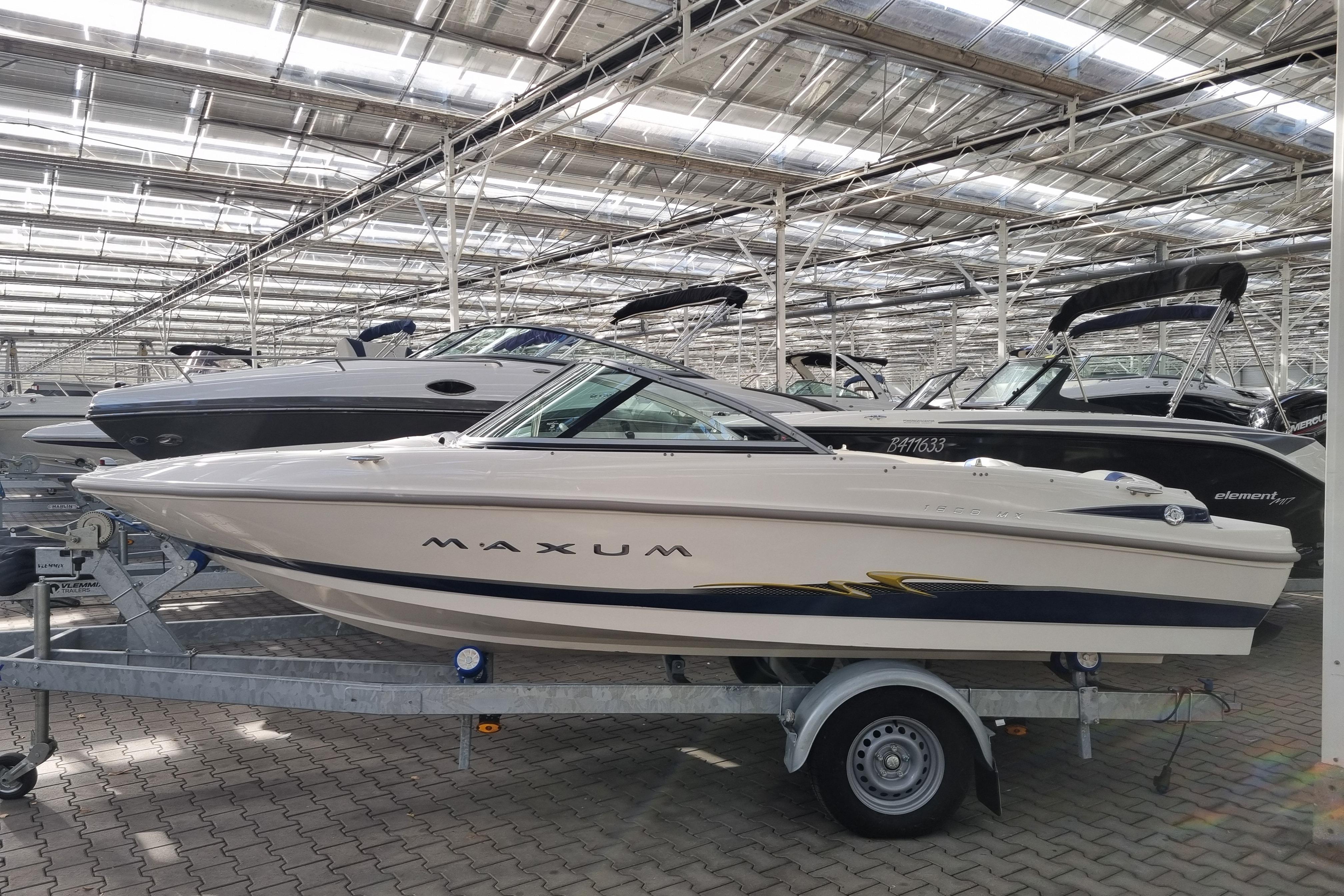 Maxum 1800 MX 2005 Maxum 1800 MX boat on trailer in indoor showroom, surrounded by other boats.