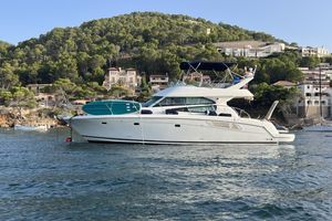 Jeanneau Prestige 42 Fly 2008 Jeanneau Prestige 42 Fly yacht anchored near scenic coastal hillside.