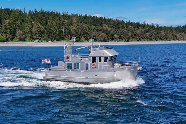 North Wind 50' LRC Aluminum Trawler North Wind 50' LRC Aluminum Trawler cruising on blue water, forested shoreline in background.