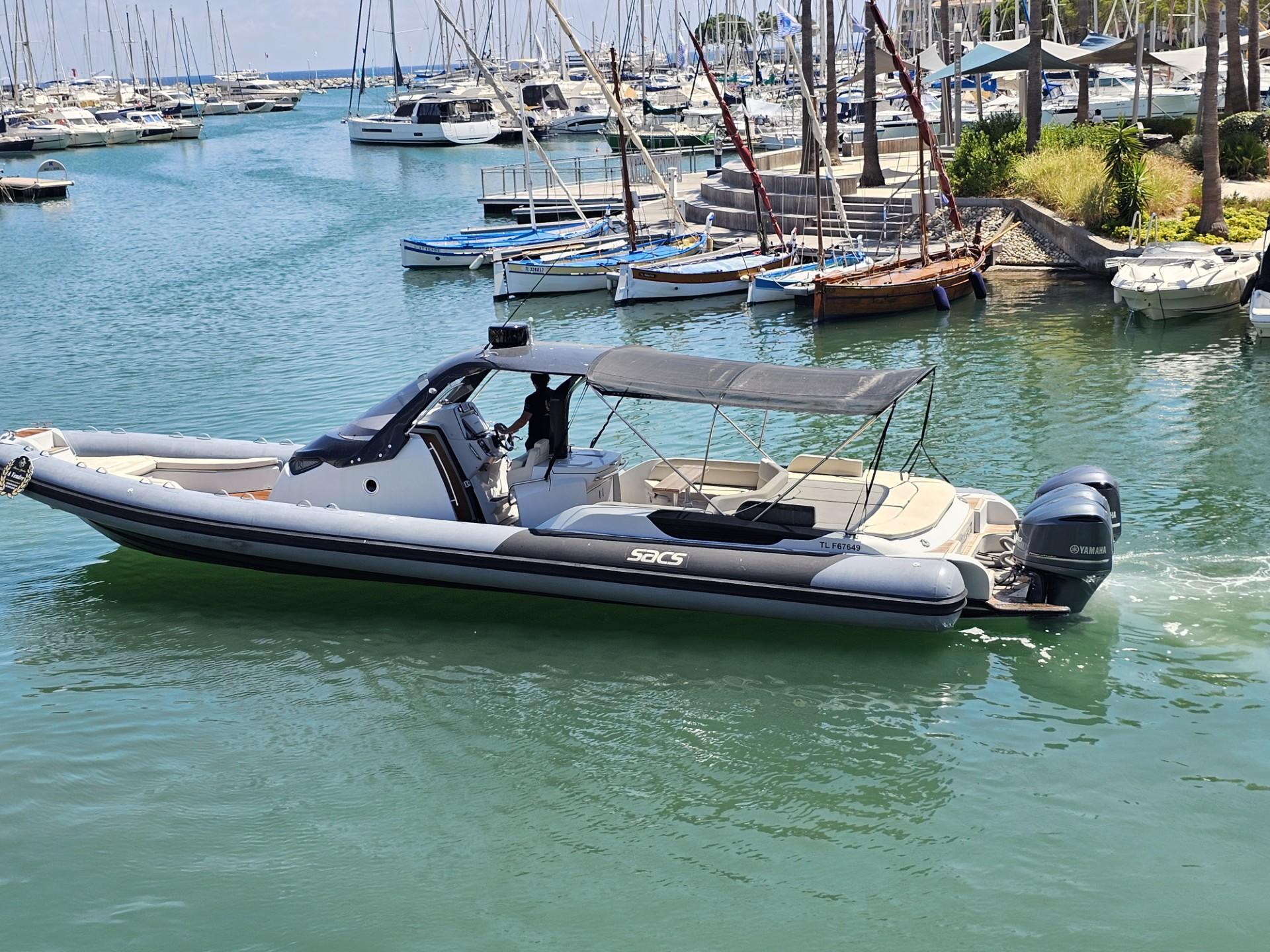 SACS Strider 13 2013 SACS Strider 13 boat cruising in a marina with yachts in the background.
